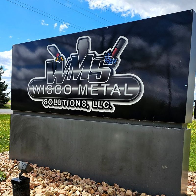 Wisco Metal Solutions, LLC sign with the company logo, outside the shop